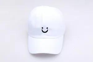 Detailopname van zwart geborduurde smile op een premium witte katoenen baseballpet