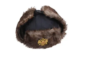 Detail einer russischen Ushanka-Mütze mit goldenem Adler-Abzeichen und braunem Kunstpelz