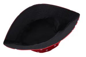 Detail view of the reversible red bucket hat with white polka dots and black inner lining