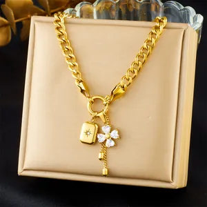 Detail of gold Cuban chain necklace with sparkling heart clover and starburst pendant
