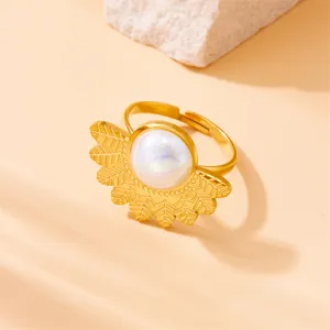 Close-up of golden adjustable ring with iridescent pearl and radial leaf design details