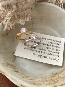 Detail of bamboo joint silver rings with sparkling diamonds in a vintage ceramic dish