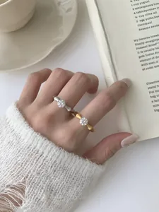 Detail of gold and silver bamboo-style rings with crystals on a cozy knit background