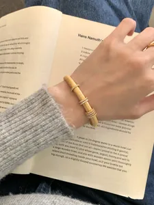 Detalle del brazalete de plata dorada cepillada con cuatro anillos de pavé deslizantes