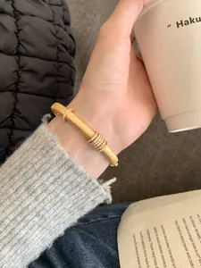 Primer plano de una pulsera de plata S925 dorada cepillada con anillos de diamantes deslizantes