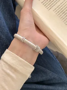 Vista de primer plano del brazalete plateado cepillado con anillos deslizantes de diamantes