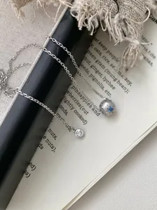 Détail macro du collier étoile en argent S925 avec texture brossée et zircon bleu