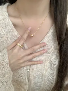Gros plan d'un collier étoile doré et d'une bague en diamants multicouches