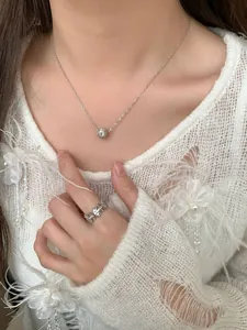 Détail du collier S925 avec breloque étoile rose et bague ajourée florale sur modèle