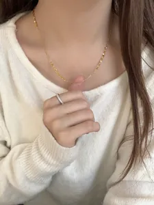 Close-up of S925 sterling silver golden waterfall chain on white knit sweater