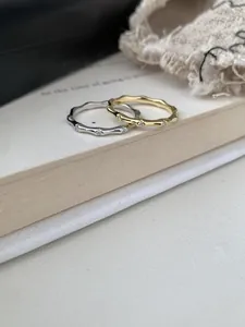 Detalle macro de anillos ondulados de plata S925 en oro y plata con pequeños diamantes engastados