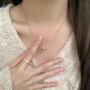 Collier étoile en argent S925 doré et bague vintage sur un pull en maille douce