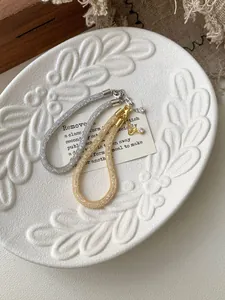 Detailed shot of woven S925 sterling silver bracelets in gold and silver with lobster clasp