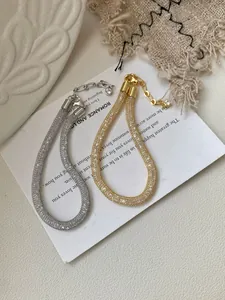 Detailed view of gold and silver glitter mesh bracelets with lobster clasps and crystals