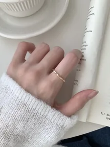 Detalle de anillo de plata S925 estilo bambú con circonitas en un dedo femenino