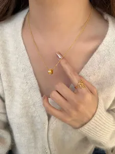Detail van de gouden kralenketting met diamanten hanger op de hals van model