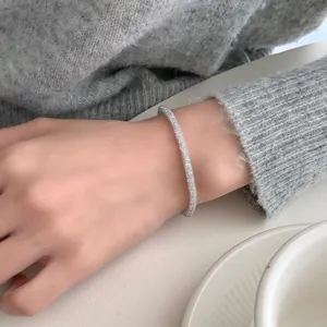 Elegant S925 sterling silver bangle with pavé-set crystals worn on a female wrist