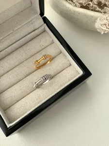 Dettaglio macro di anelli S925 oro e argento con finitura spazzolata e piccoli anelli con diamanti