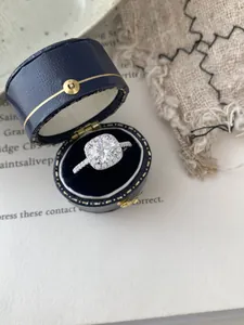 Macro view of a classic halo moissanite ring with pavé diamonds in a velvet box