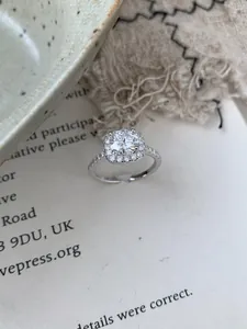 Close-up of S925 sterling silver moissanite halo ring with adjustable open band design