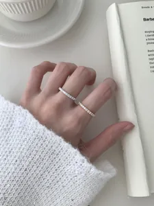 Gros plan de bagues d'éternité superposées en argent S925 et or avec zircons cubiques