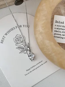 Dettaglio ravvicinato di una collana in argento S925 con zircone solitario su carta regalo