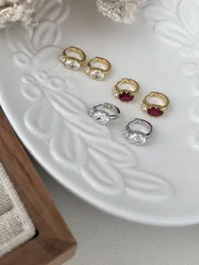 Detailed macro view of S925 silver stud earrings with oval gemstones and small side diamonds