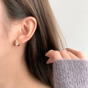 Elegant S925 silver gold-plated stud earrings with oval white crystals on model
