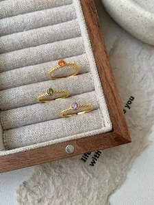 Vue macro de trois bagues en argent S925 avec pierres colorées dans un coffret à bijoux