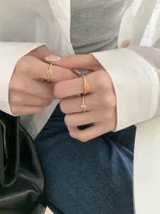Détail de trois bagues en argent S925 avec gemmes colorées et texture tressée dorée en gros plan
