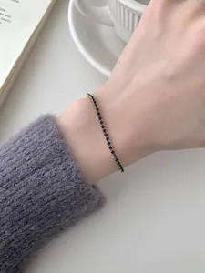 Detailansicht eines S925 Silber Tennisarmbands mit tiefblauen Edelsteinen in Gold