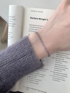 Details eines verstellbaren Silberarmbands mit runden lila Edelsteinen am Handgelenk