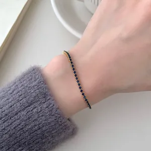 Elegantes vergoldetes Tennisarmband mit dunkelblauen Zirkonia am Handgelenk