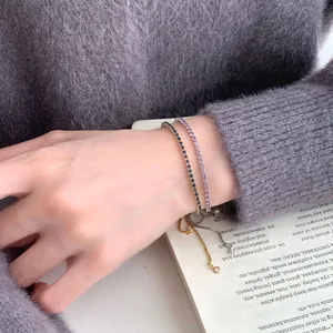 Verstellbare S925 Sterling Silber Armbänder mit Zirkonia-Steinen auf grauem Strickpullover