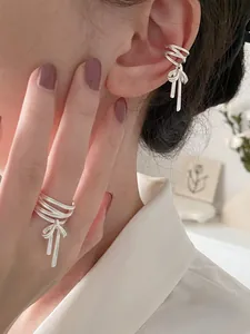 Silbernes Set aus Schleifenring und Ohrmanschette mit Quasten an einem Modell