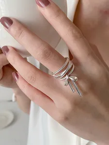 Detailansicht eines S925 Silber-Mehrlagenrings mit einem zarten Schleifenanhänger