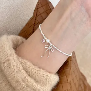 S925 sterling silver beaded bracelet with pink heart gem, pearl, and bow charm on wrist