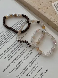 Dettaglio di braccialetti in argento S925 con perline in legno e pietre naturali colorate