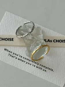 Vue macro de bagues plissées argent et or avec zircons sur pierre de cristal brute