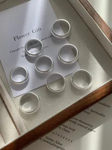 Macro detail of matte S925 sterling silver minimalist rings in a wooden tray