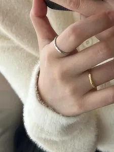 Détail de la bague argentée martelée et de l'anneau doré orné de petits cristaux