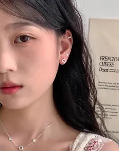 Dettaglio ravvicinato di orecchini a lobo croissant in argento S925 indossati da una modella