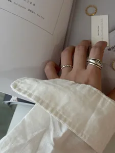 Gros plan de bagues empilables en argent sterling S925 et anneau multicouche au doigt