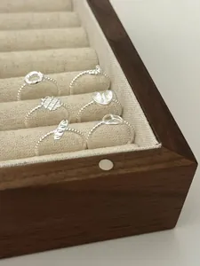 Detailaufnahme von sechs silbernen Croissant-Ringen in einer Schmuckschatulle