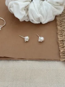 Gros plan de boucles d'oreilles en argent S925 et perles sur papier rustique et tissu