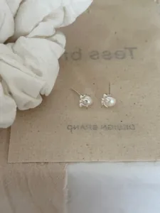 Gros plan de boucles d'oreilles en argent S925 avec perles d'eau douce sur tissu beige