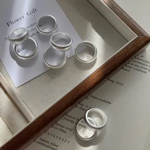 Matte S925 sterling silver minimalist rings on a vintage aesthetic background
