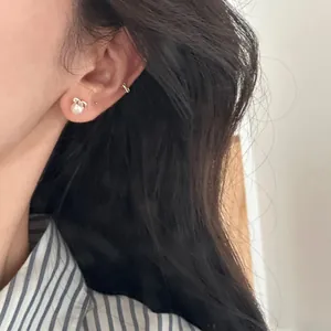 Élégante boucle d'oreille perle argent S925 avec nœud et manchette sur modèle