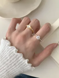 Detalle de anillos giratorios de plata S925 con circonitas brillantes en los dedos