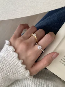 Vista detallada de anillos giratorios de oro y plata con circonitas usados en los dedos